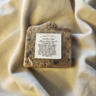 soap bar with flecks of black and deep red with product label