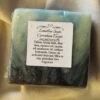 soap bar with splashes of black, greens, and blues, and the product label
