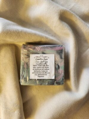 soap bar with swirls of black, teal, and pink with product label