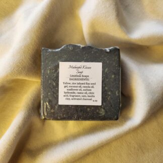 black soap bar with flecks of color with product label