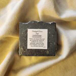black soap bar with flecks of color with product label