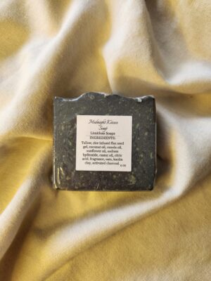 black soap bar with flecks of color with product label