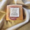 soap bar with swirls of orange and pink with product label