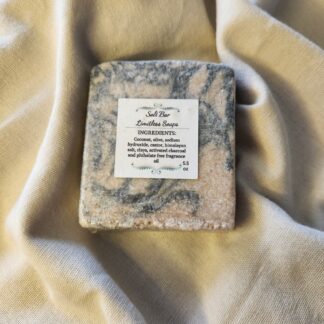 salt soap bar with swirls of pale pink and black with product label