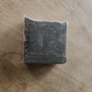 black soap bar with flecks of brown