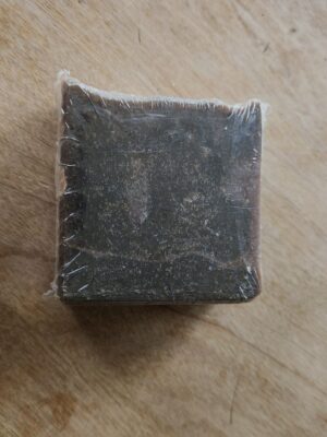 black soap bar with flecks of brown